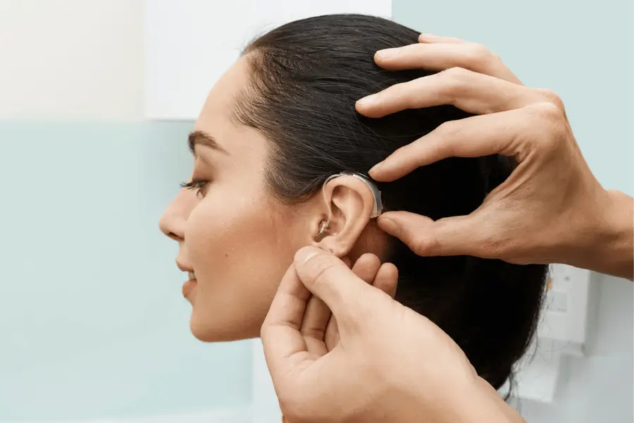 Audiologist fitting a behind-the-ear hearing aid for a patient at DEB's Audiology, Mumbai